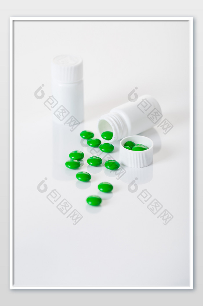 白瓶绿色药片摄影图片