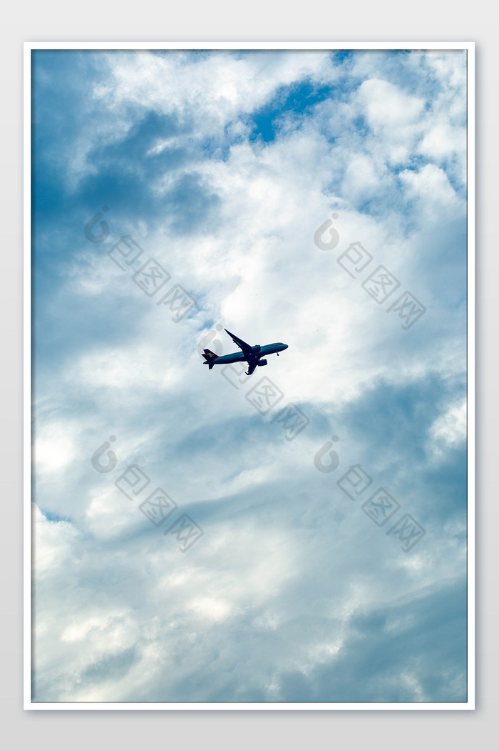 飞机飞在蓝天白云的天空中摄影图