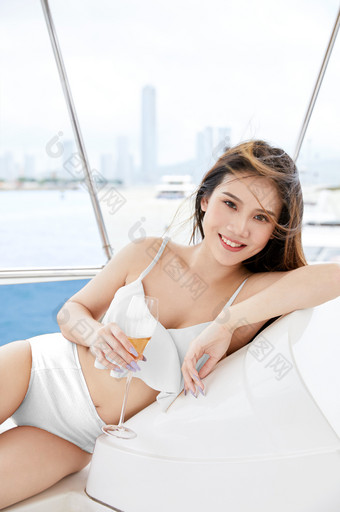 海滨端着香槟倚靠游艇美女比基尼泳装样机图片