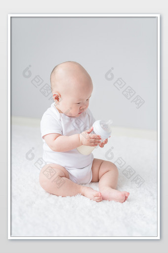 儿童母婴婴儿抱着奶瓶玩摄影图片