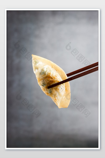 用筷子夹起美食煎饺特写图片