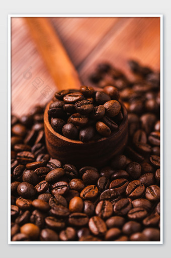 咖啡豆与咖啡勺散落在桌面上图片