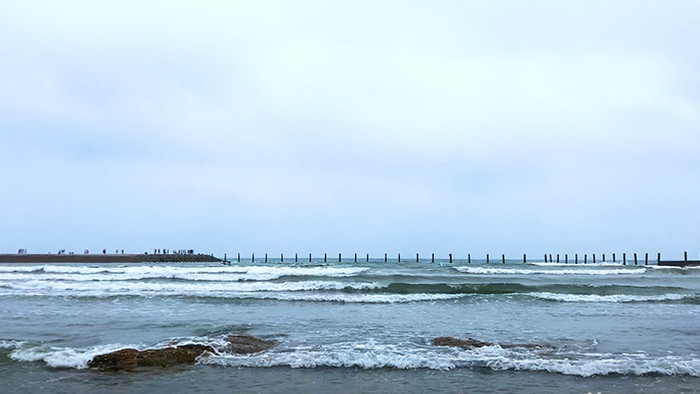 山东青岛第一海水浴场堤坝海浪沙滩游轮素材