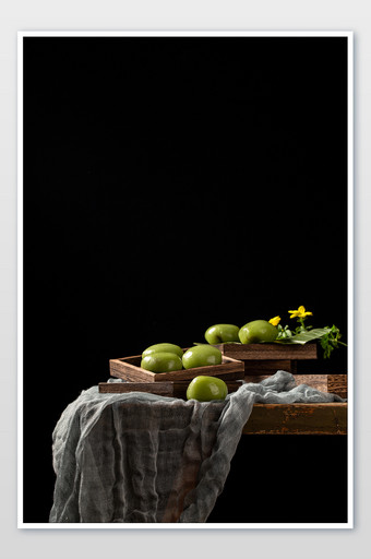 黑色背景里的木桌上一碟美食小吃青团摄影图图片