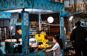 夜市里在地摊摊位买冷饮的小女孩图片