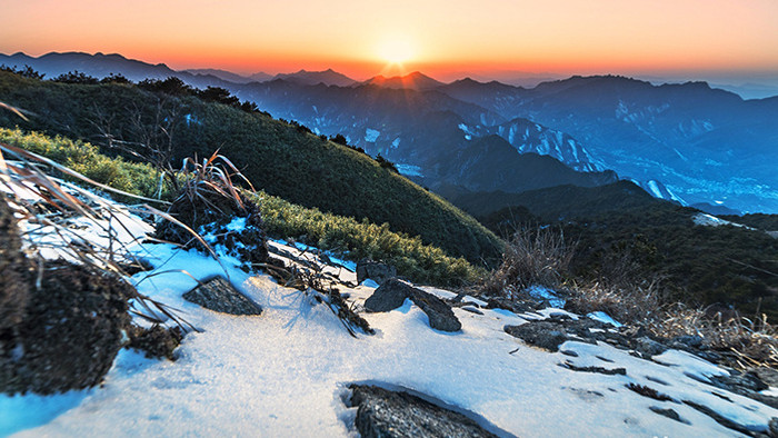 群山间冰雪覆盖的山峰日出