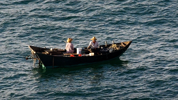金黄色晨曦下的渔船渔民海上钓鱼高清实拍