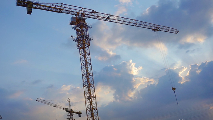 夕阳下城市建筑工地施工塔吊挖机实拍视频