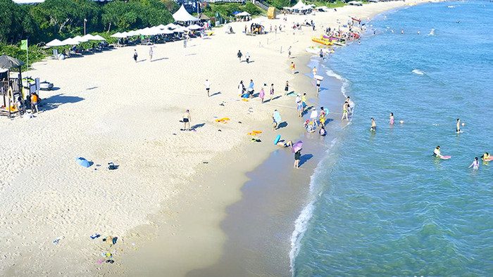 4K航拍三亚旅游海边沙滩休闲的人们视频素