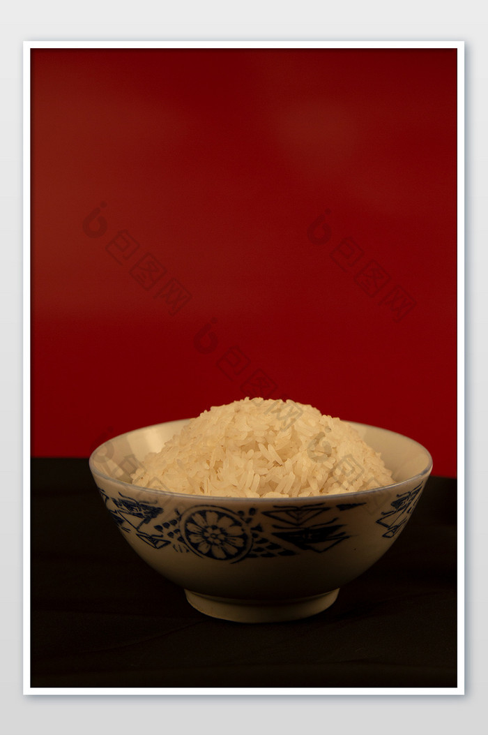 红色纯色背景前的一碗米饭