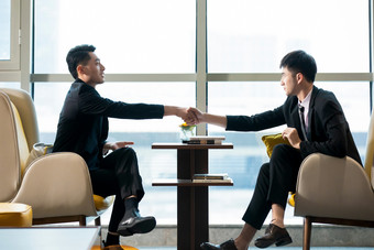 西装男面谈客户谈合作握手