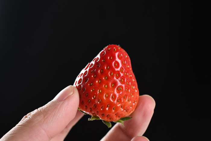 新鲜草莓水果手拿图片