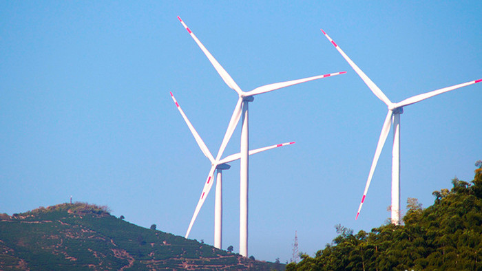 航拍群山间转动的风力发电站