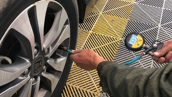实拍汽车修理工测量轮胎胎压