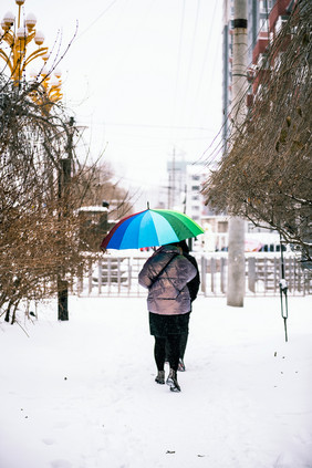 下雪天在公园小路行走的打伞路人