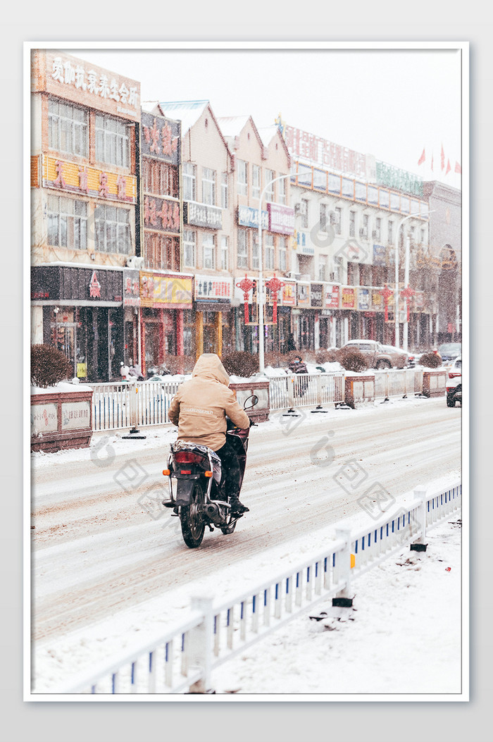 城市大雪中骑摩托车的行人实拍摄影图