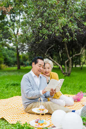 清新老年夫妇野外阅读摄影照片