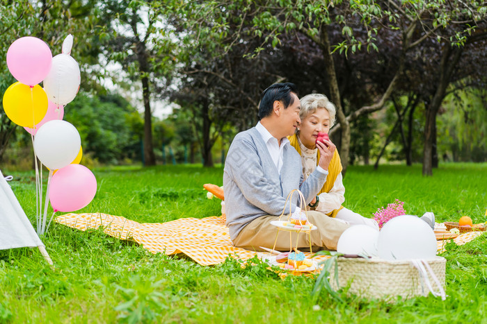 清新老年夫妇野外露营喂苹果摄影照片图片