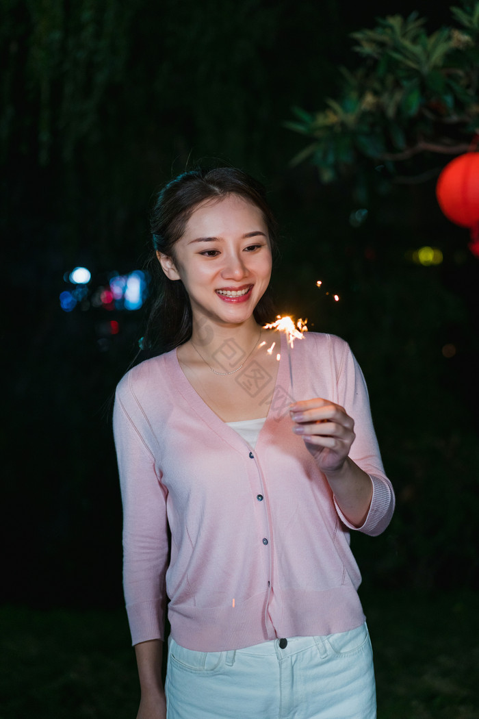 新年年轻妈妈夜晚放呲花摄影图片