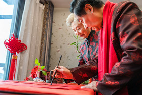 新年爷爷奶奶侧面写对联摄影图片