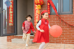 新年红衣男女孩奔跑嬉戏摄影图片