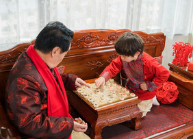 新年爷爷教孙子下象棋摄影图片