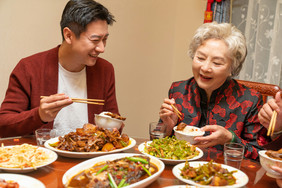 新年爸爸给奶奶夹菜团圆饭摄影图片