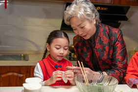 新年奶奶教孙女包饺子摄影图片