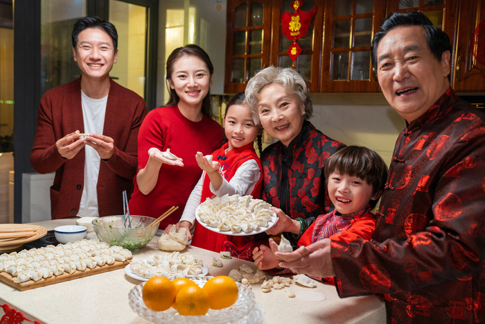 新年一家人包饺子侧面摄影图片
