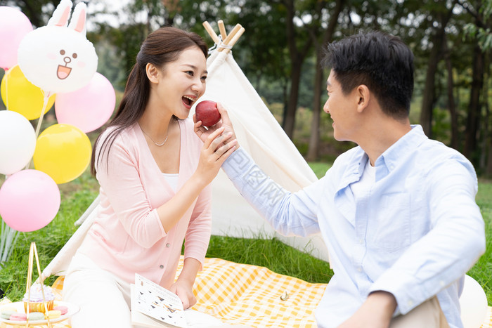 清新年轻男女野外吃苹果摄影图片