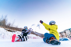 身穿滑雪服在雪地打雪仗