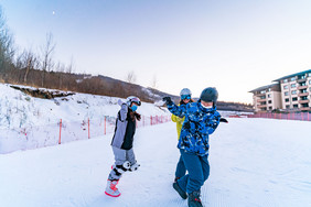 两个身穿滑雪服的人雪地打雪仗