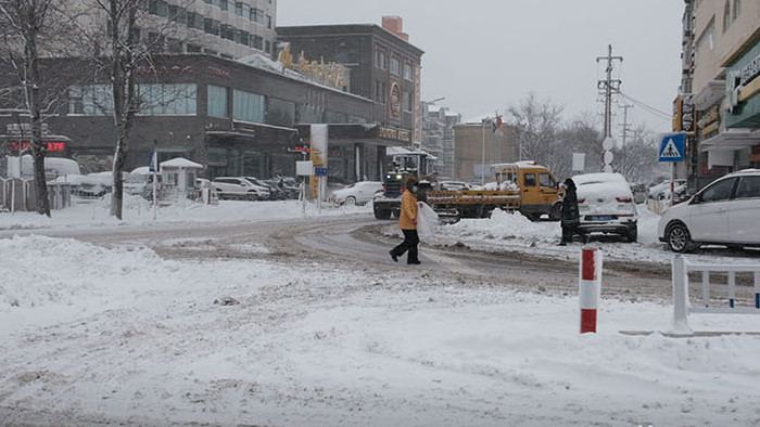 暴雪天气城市交通不畅重型车辆清楚路面积雪