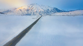 航拍阳光雪景雪山冬天公路