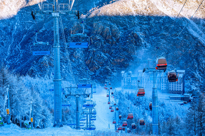 冬季在山林间穿过的滑雪缆车图片
