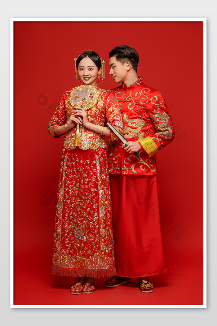 穿着传统中式礼服的新郎看向新娘
