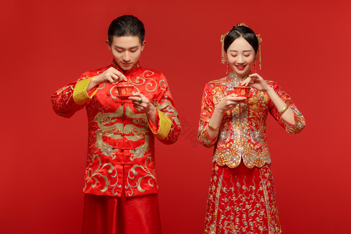 穿着中式传统婚服的新人喝茶图片