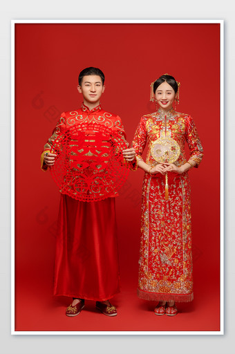 穿着中式传统婚服的新人举着喜字图片