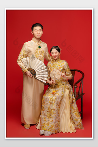 穿着金色传统婚服的新人合影图片