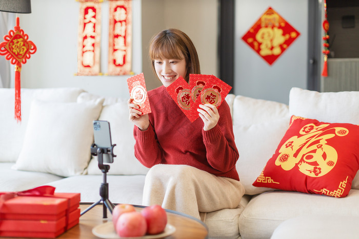 新年春节居家女生对着手机展示红包图片