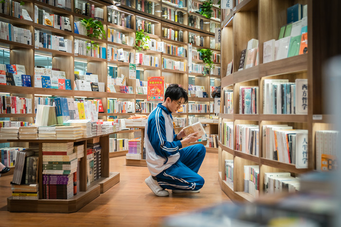 校园生活男学生图书馆半蹲阅读图片