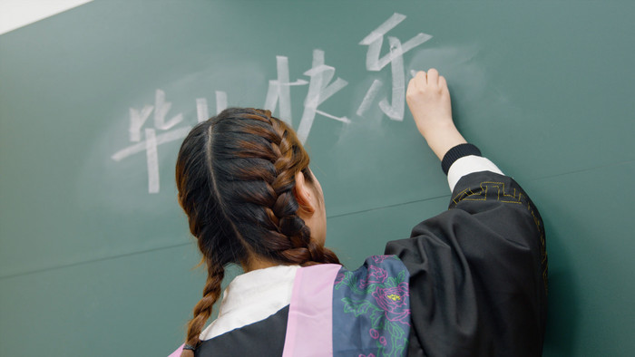 大学生在黑板写下毕业快乐实拍