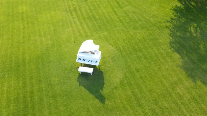 4K航拍唯美浪漫绿色草坪上的钢琴