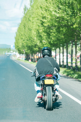 夏日公路上骑摩托车的路人