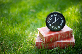 草地上的闹钟和书本