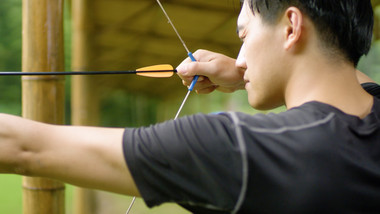 户外男子拉弓射箭瞄准特写实拍