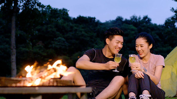 露营夜晚野餐饮酒的年轻情侣实拍