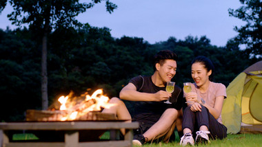 露营夜晚野餐饮酒的年轻情侣实拍