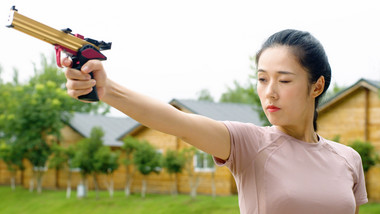 女生手持电子枪瞄准射击实拍