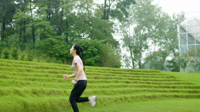 女子绿色草地上奔跑实拍